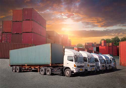  Trucks parked in front of cargo containers.