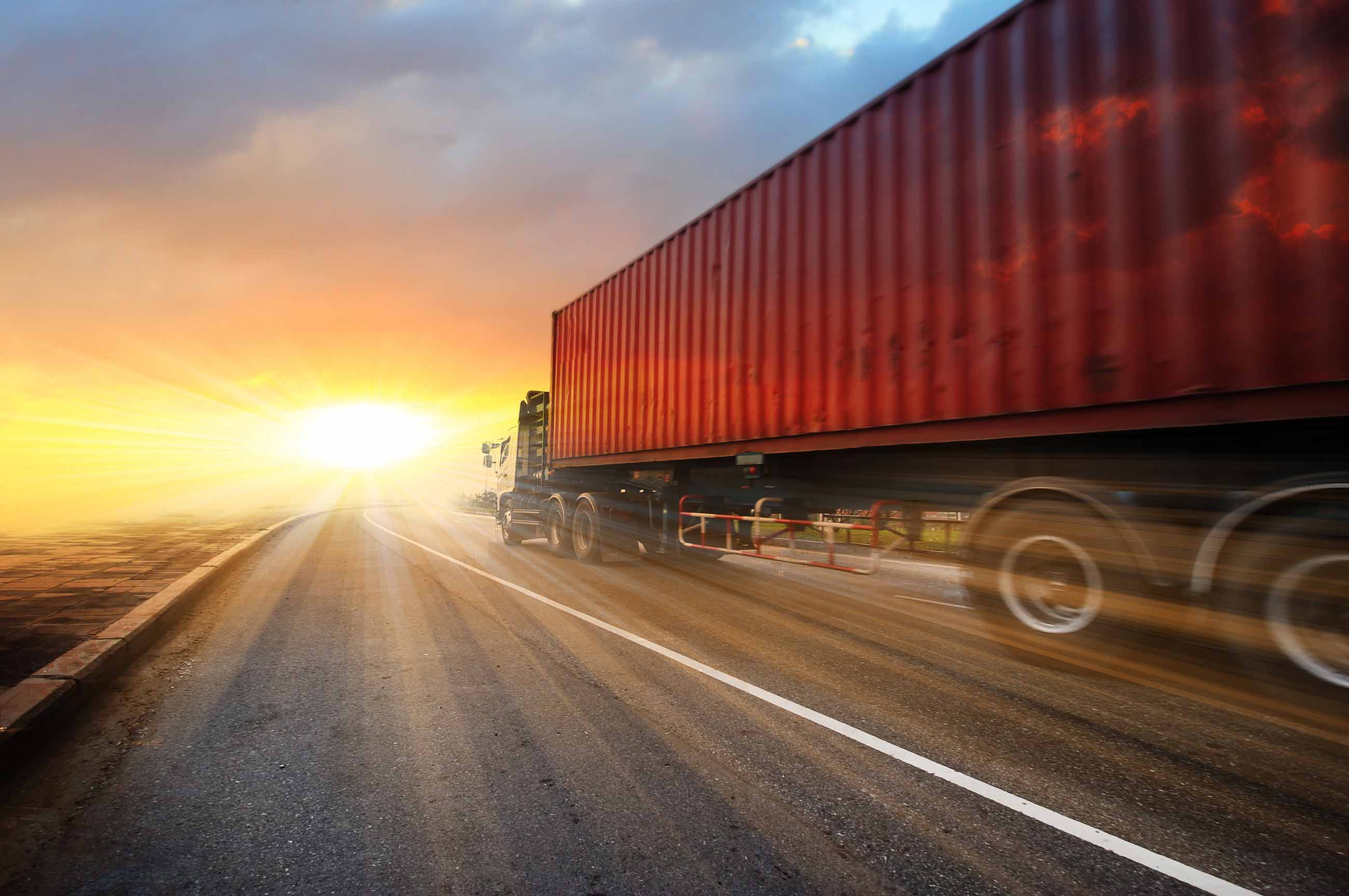 truck carrying cargo container speeding down highway